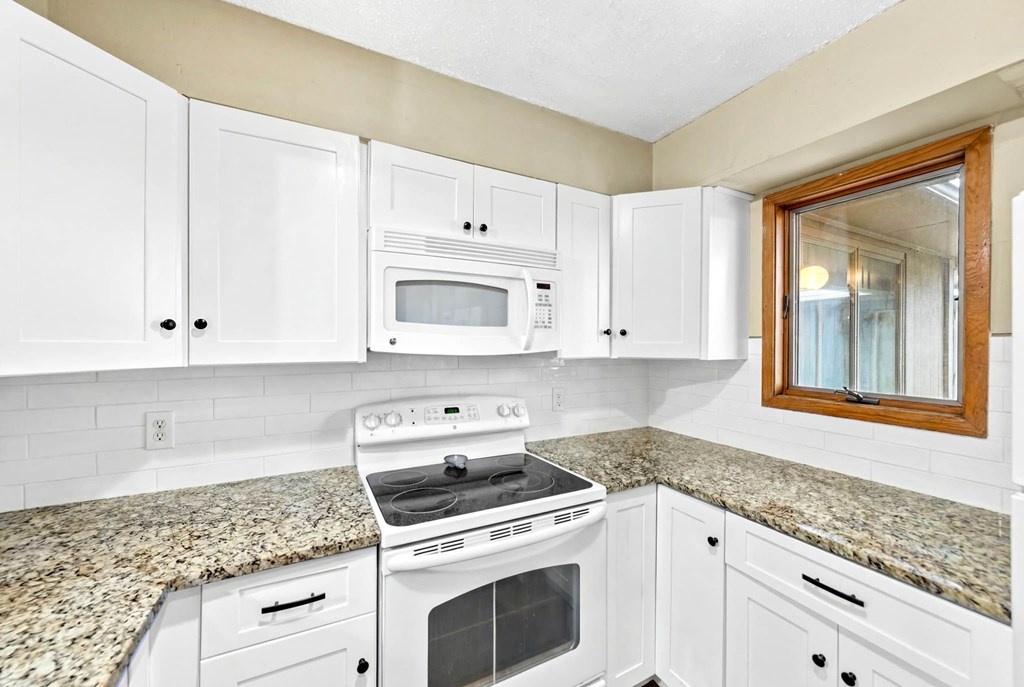 805-119 Highway 534 Loop Kerrville, TX 78028 - Photo 10 of 23 a kitchen with granite countertop white cabinets and white appliances