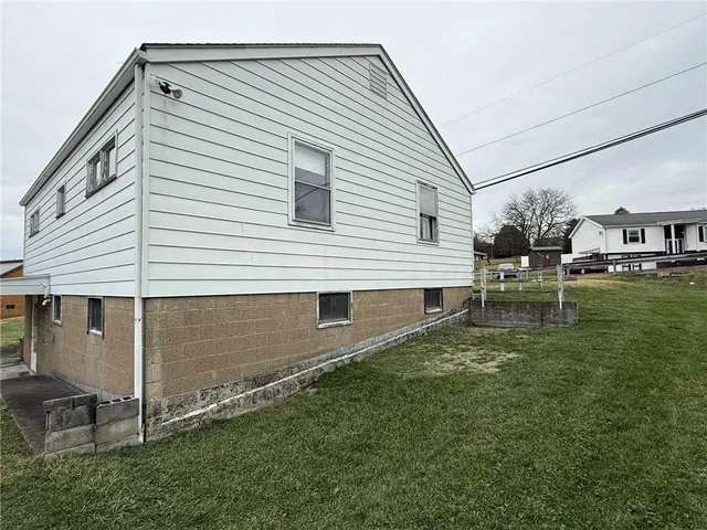 a backyard of a house with table and chairs