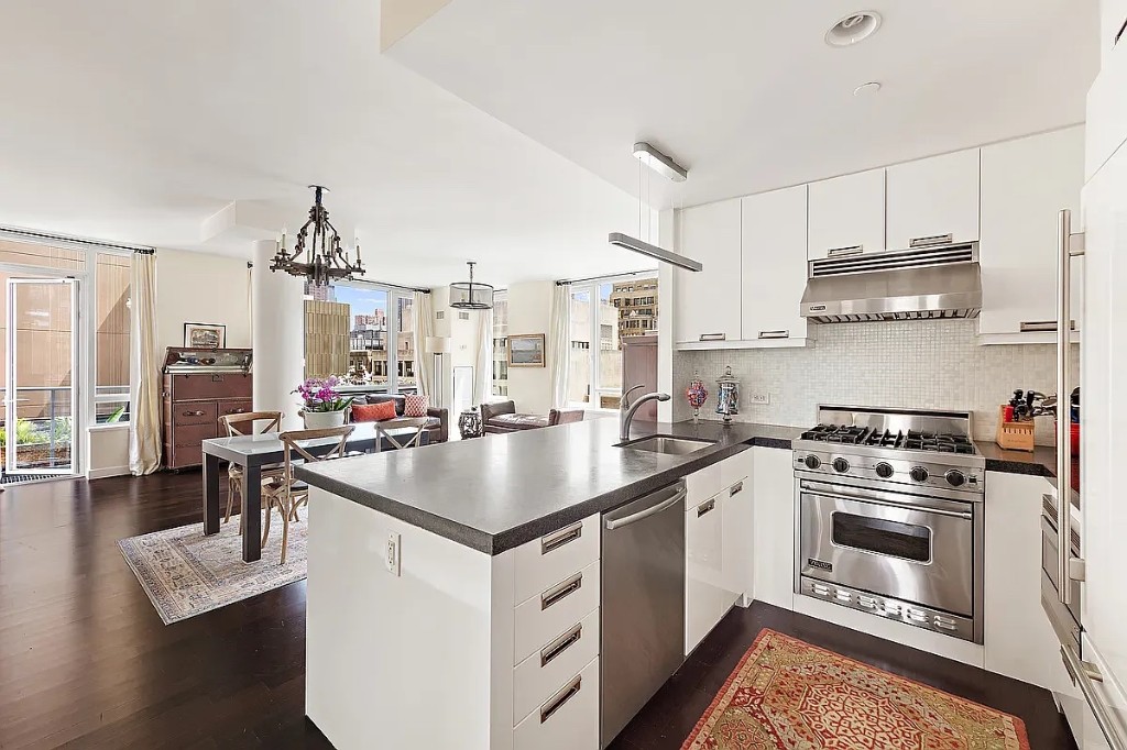261 West 28th Street, Unit 10D Manhattan, NY 10001 - Photo 9 of 19 a kitchen with stainless steel appliances granite countertop a stove a sink dishwasher a refrigerator white cabinets and wooden floor