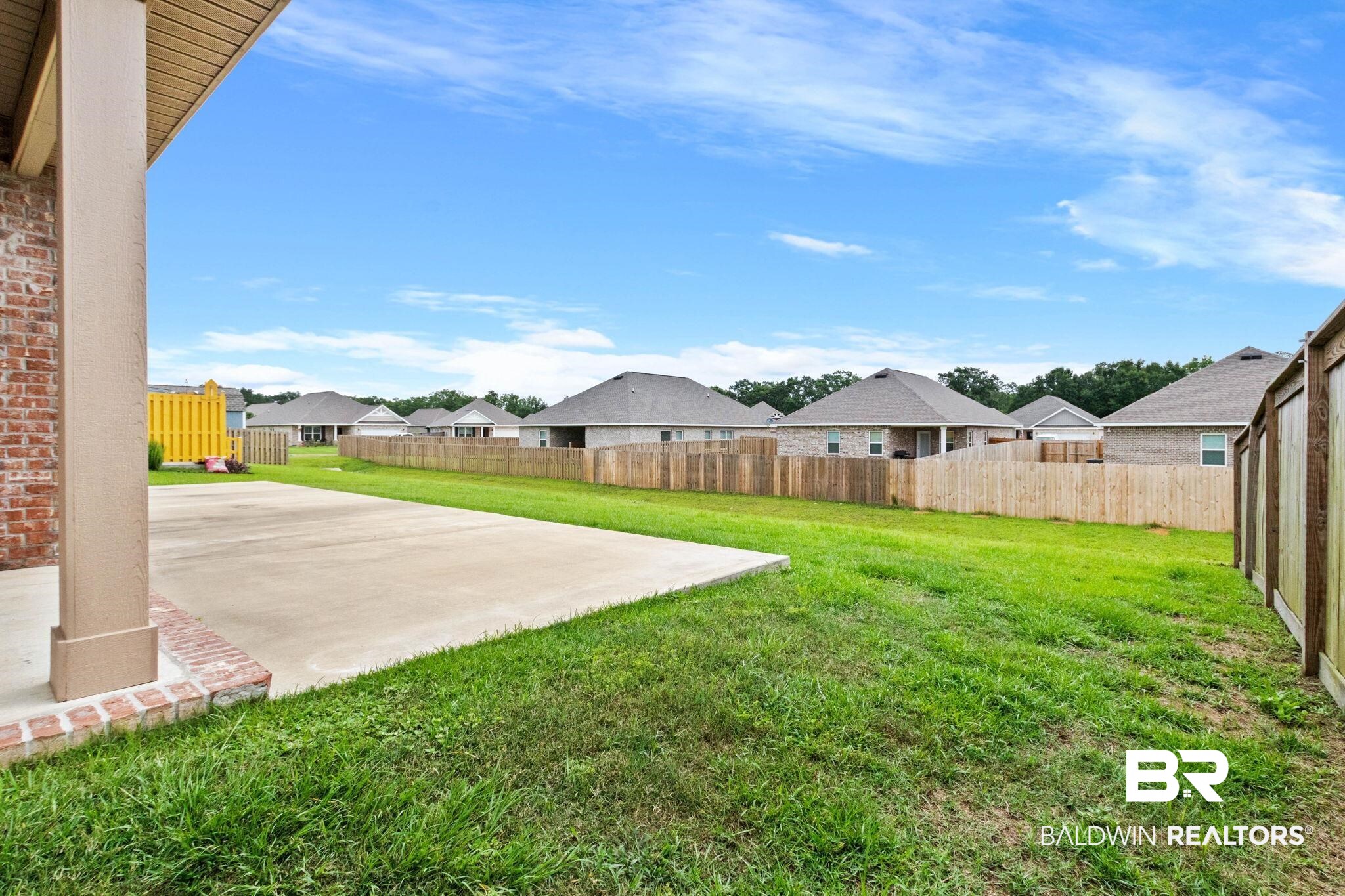 1710 Grouse Street Foley, AL 36535 - Photo 69 of 76 Expansive concrete patio with a brick column base and a large grassy area
