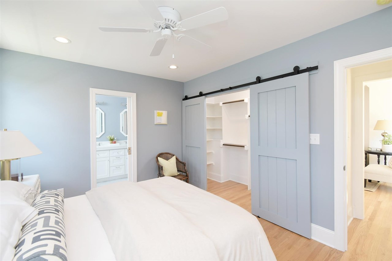 2017 Pine Drive Raleigh, NC 27608 - Photo 13 of 25 a bedroom with a large bed and a chandelier