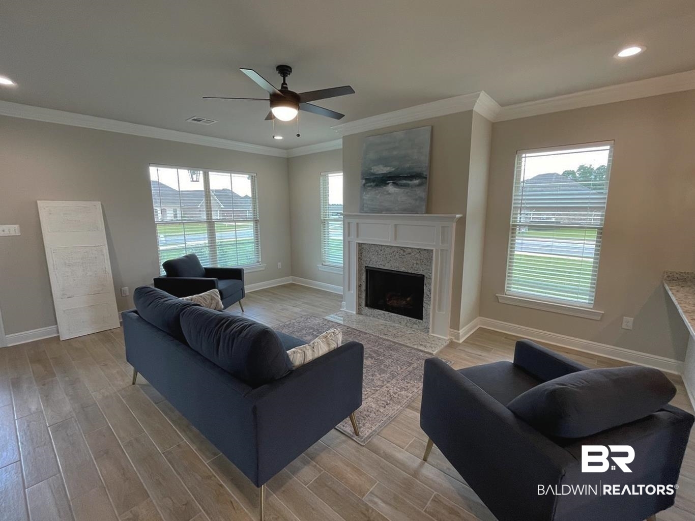 9961 Chipper Lane Foley, AL 36535 - Photo 5 of 16 Living room with crown molding, a fireplace, ceiling fan, and hardwood / wood-style floors