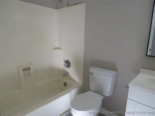 a white toilet sitting next to a bath tub