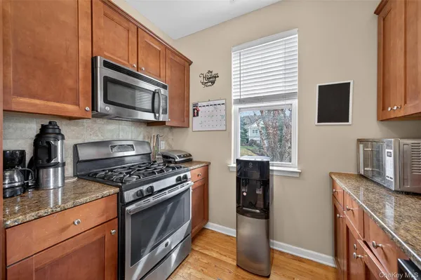 a kitchen with stainless steel appliances granite countertop a stove microwave and sink