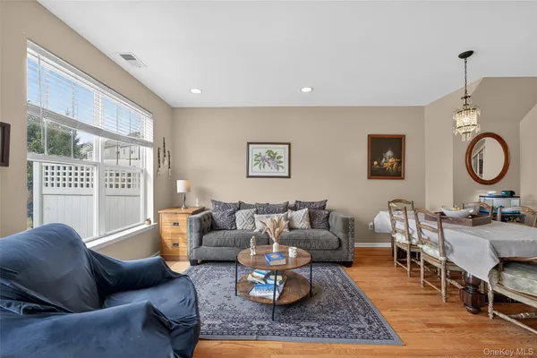 a living room with furniture wooden floor and a window