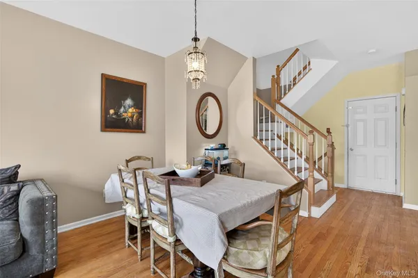 a view of a dining room with furniture a chandelier and wooden floor