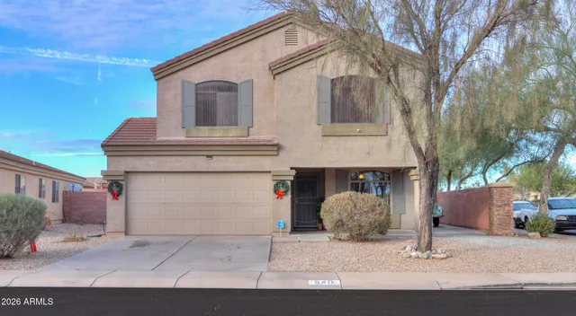 a view of a white house with large windows and a tree