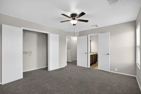 a view of an empty room with a ceiling fan