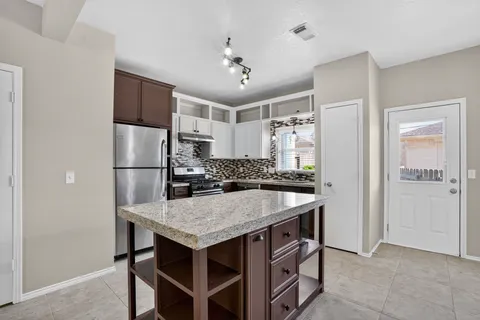 a kitchen with a table and refrigerator