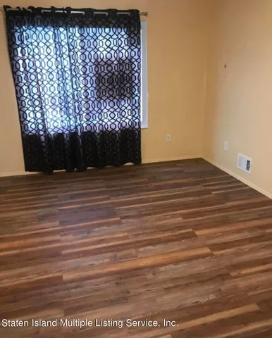 a view of a room with wooden floor