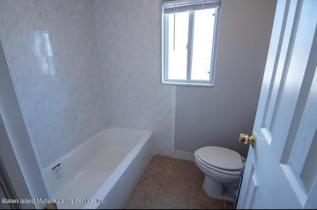 a white toilet sitting next to a bath tub