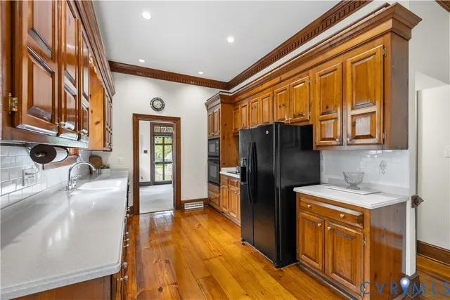 a kitchen with a refrigerator a sink and wooden cabinets