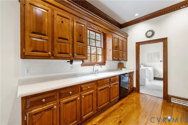 a kitchen with stainless steel appliances granite countertop a sink and cabinets with wooden floor
