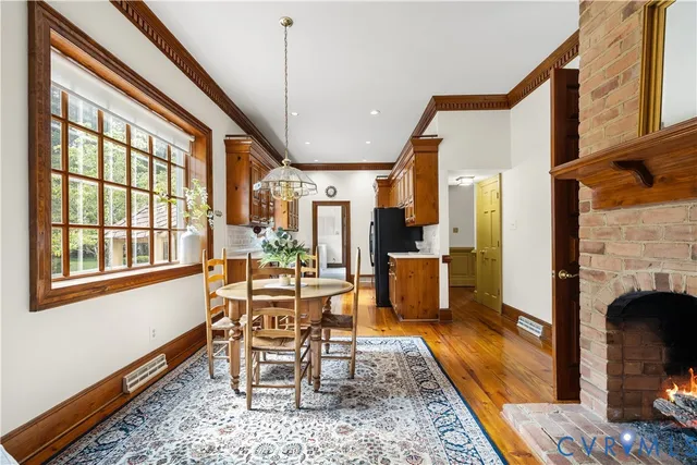 a dining room with furniture a fireplace and wooden floor