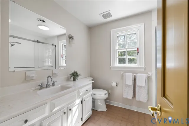a bathroom with a double vanity sink toilet and a mirror