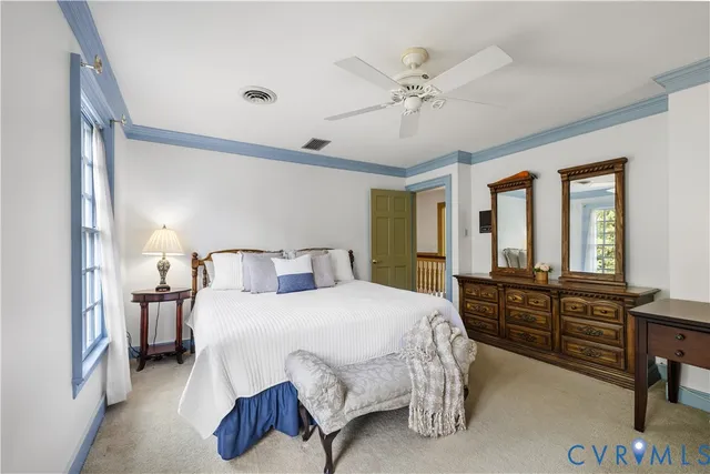 a spacious bedroom with a bed and dresser with mirror