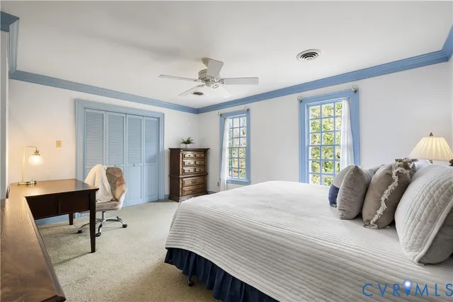 a bedroom with a bed a chair and a chandelier