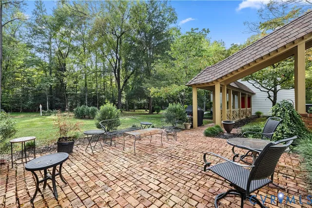 a view of a chair and table in backyard of the house