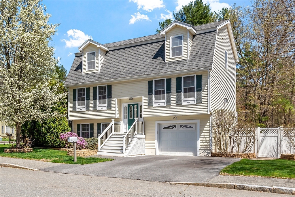 107 Charant Road Lowell, MA 01854 - Photo 2 of 30 a front view of a house with a garden and trees