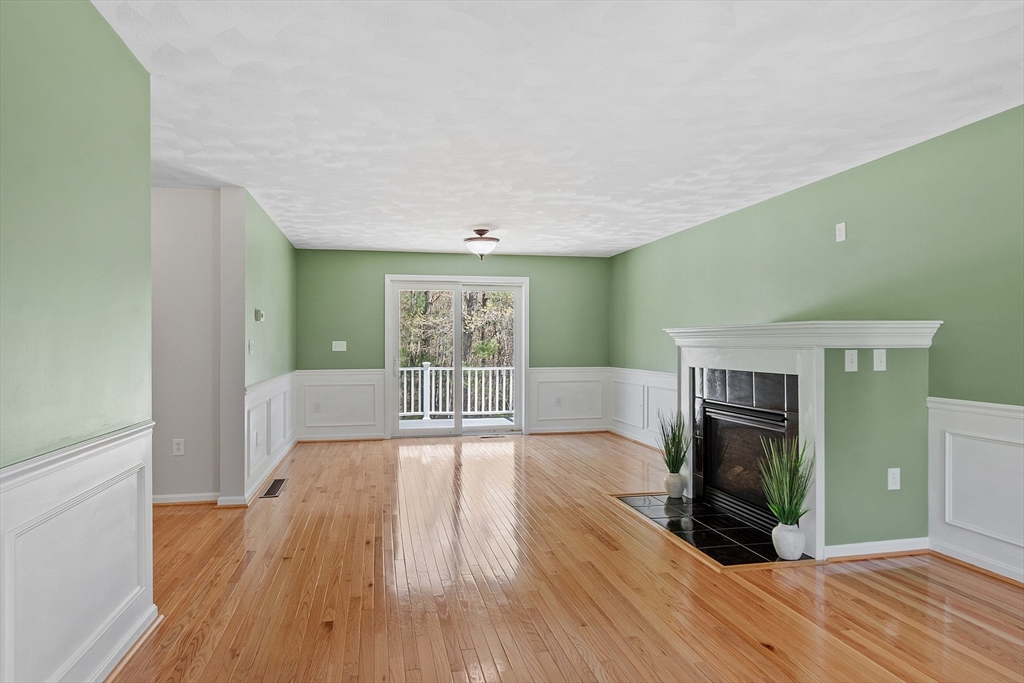 107 Charant Road Lowell, MA 01854 - Photo 5 of 30 a view of a livingroom with wooden floor and a fireplace