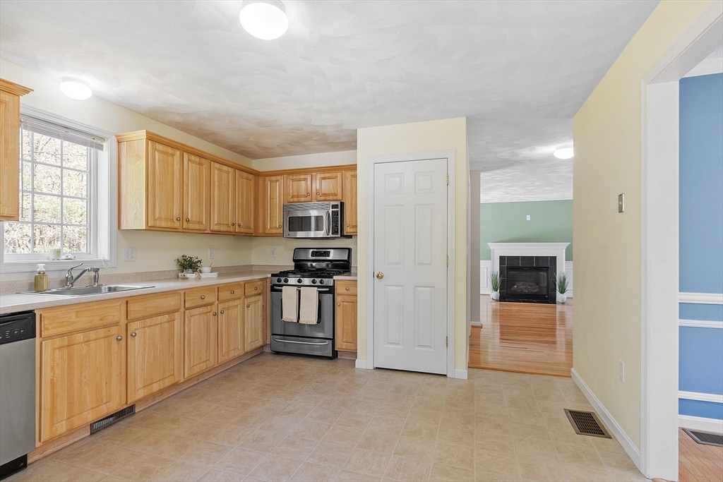 107 Charant Road Lowell, MA 01854 - Photo 8 of 30 a large kitchen with cabinets and stainless steel appliances