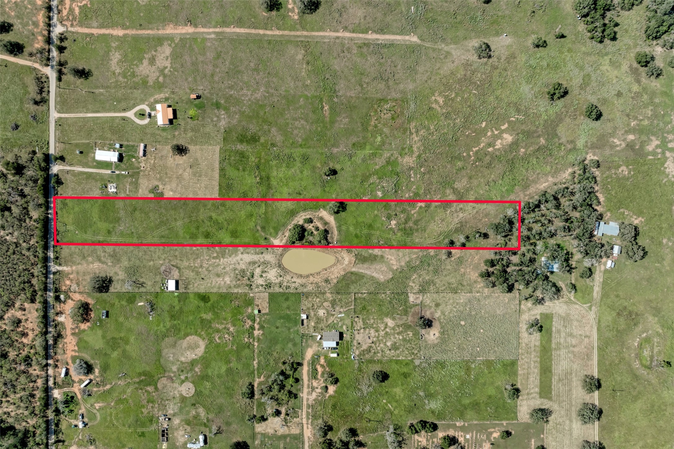 5309 Tenney Creek Road Luling, TX 78648 - Photo 16 of 23 Vast green acres with an inviting pond and ample space for agricultural pursuits.
