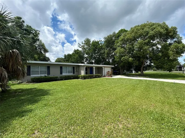 a house with green field in front of it