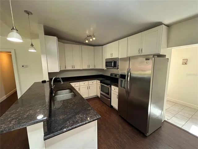 an empty room with wooden floor fireplace and windows
