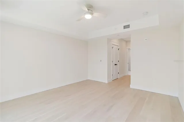 an empty room with an entryway and fan