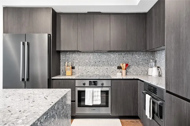 a kitchen with stainless steel appliances granite countertop a refrigerator sink and stove