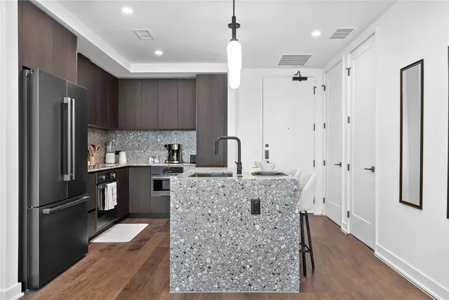 a kitchen with stainless steel appliances granite countertop a refrigerator and a sink
