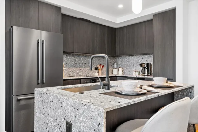 a kitchen with stainless steel appliances granite countertop a sink refrigerator and cabinets