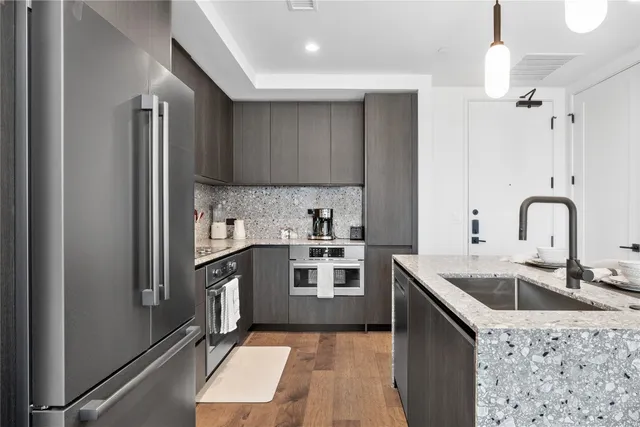 a kitchen with stainless steel appliances granite countertop a sink stove and refrigerator