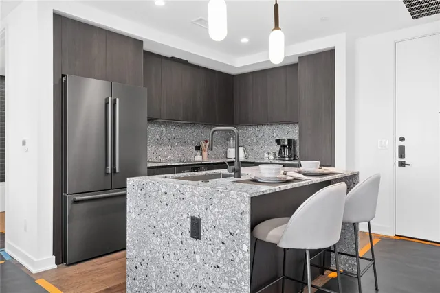 a kitchen with kitchen island a sink stainless steel appliances and refrigerator