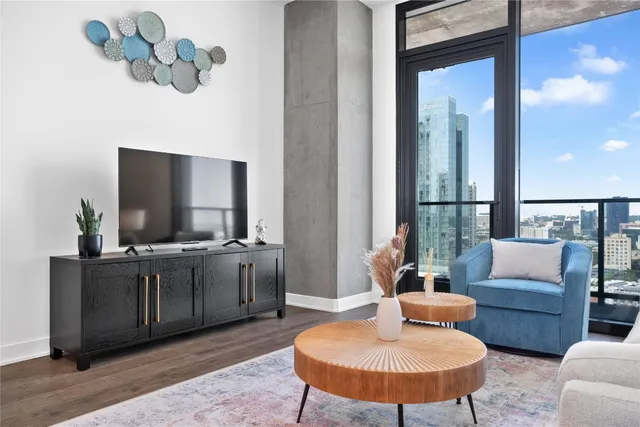 a living room with furniture a flat screen tv and a table