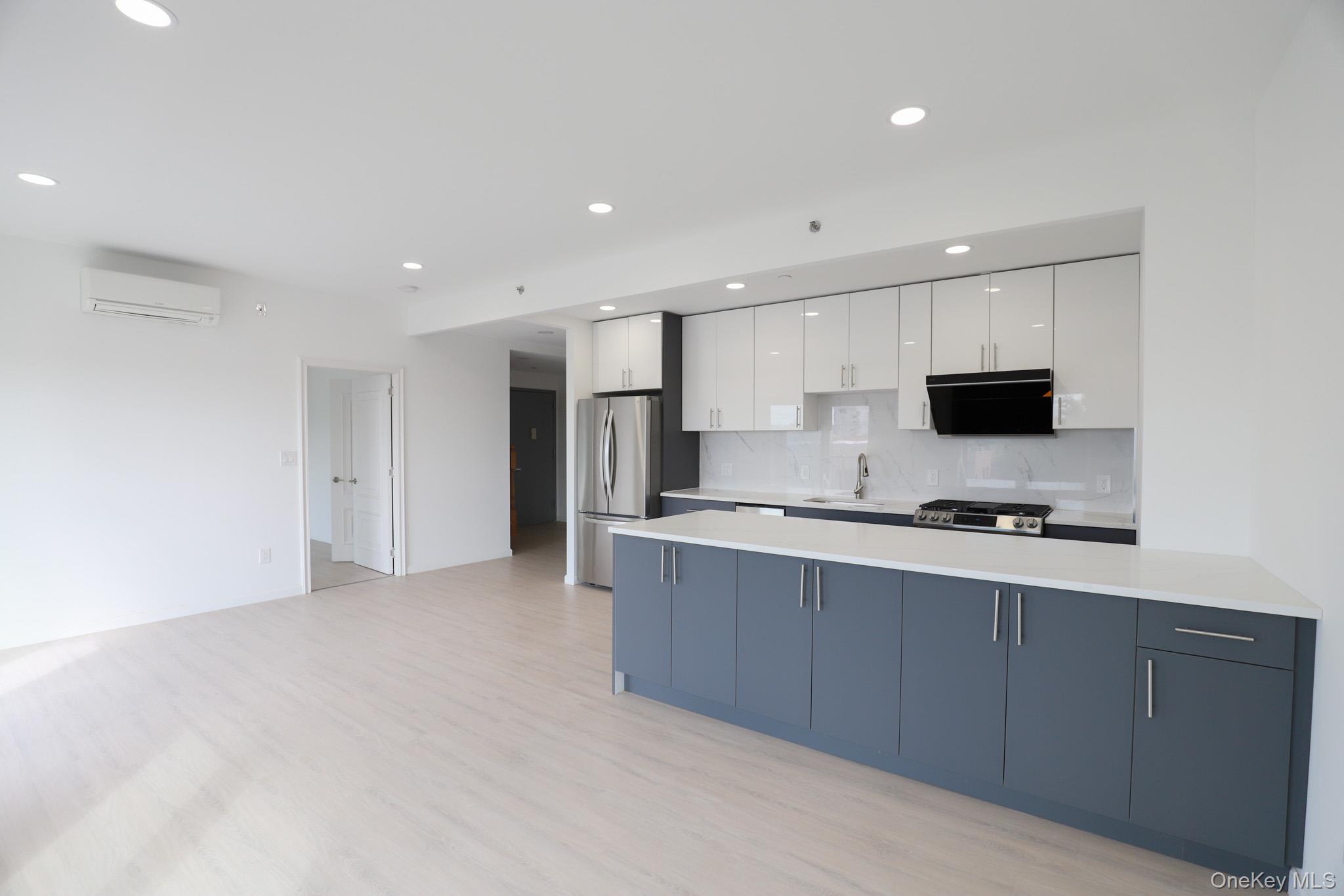 42-78 Main Street, Unit 6E Queens, NY 11355 - Photo 10 of 33 a kitchen with stainless steel appliances a stove top oven a sink a refrigerator and white cabinets
