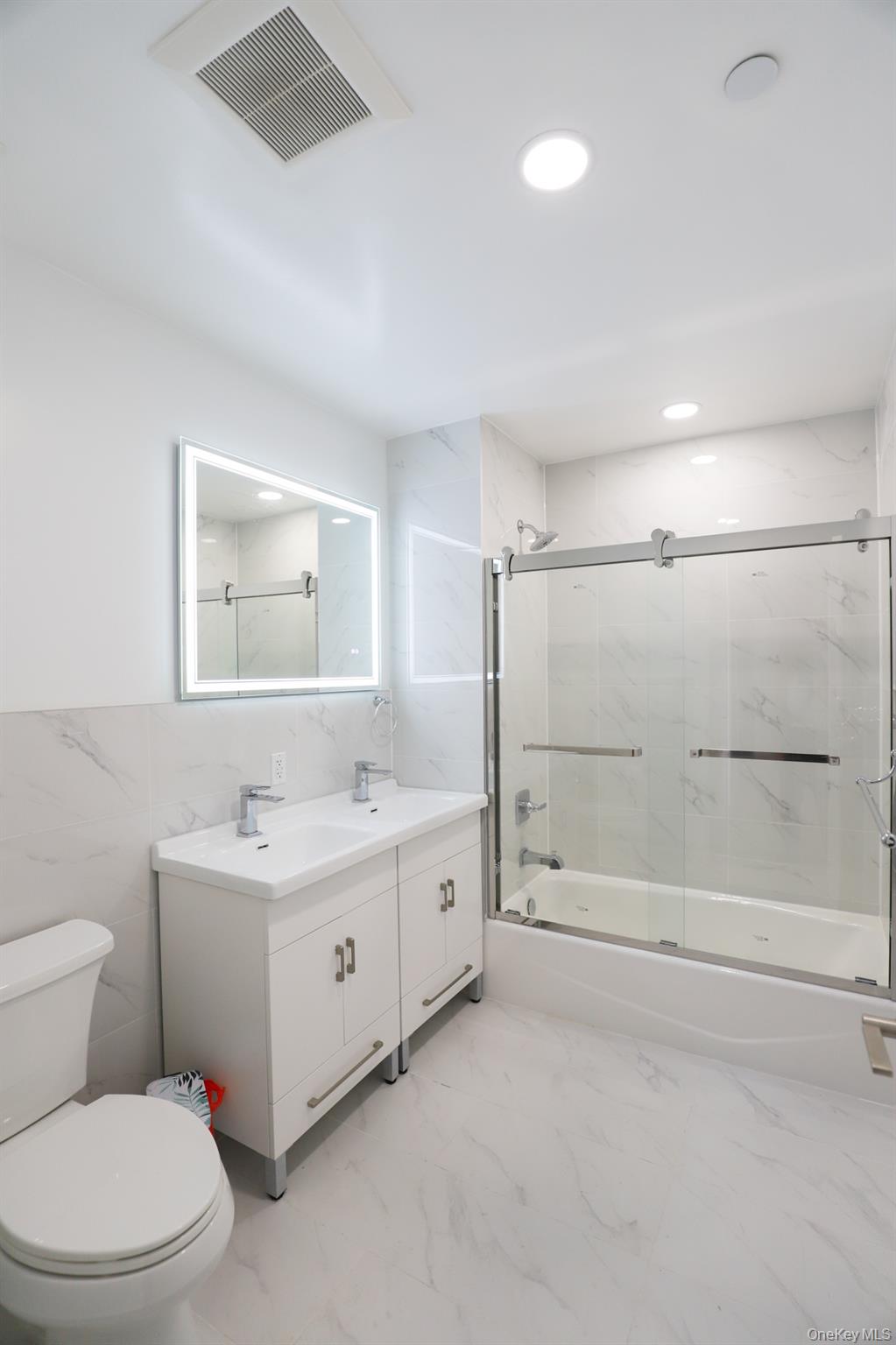 42-78 Main Street, Unit 6E Queens, NY 11355 - Photo 12 of 33 a bathroom with a double vanity sink toilet and shower