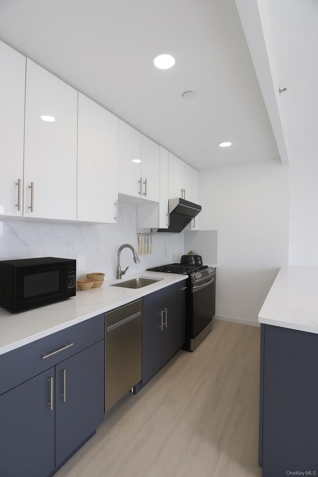 42-78 Main Street, Unit 6E Queens, NY 11355 - Photo 24 of 33 a kitchen with stainless steel appliances granite countertop a sink a stove a refrigerator and a microwave