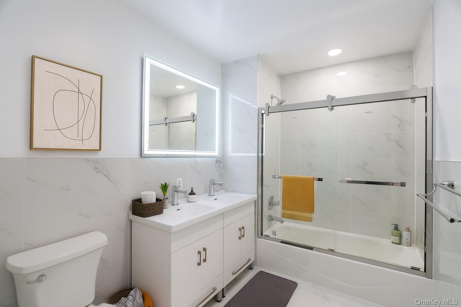 42-78 Main Street, Unit 6E Queens, NY 11355 - Photo 26 of 33 a bathroom with a bathtub shower sink vanity and toilet