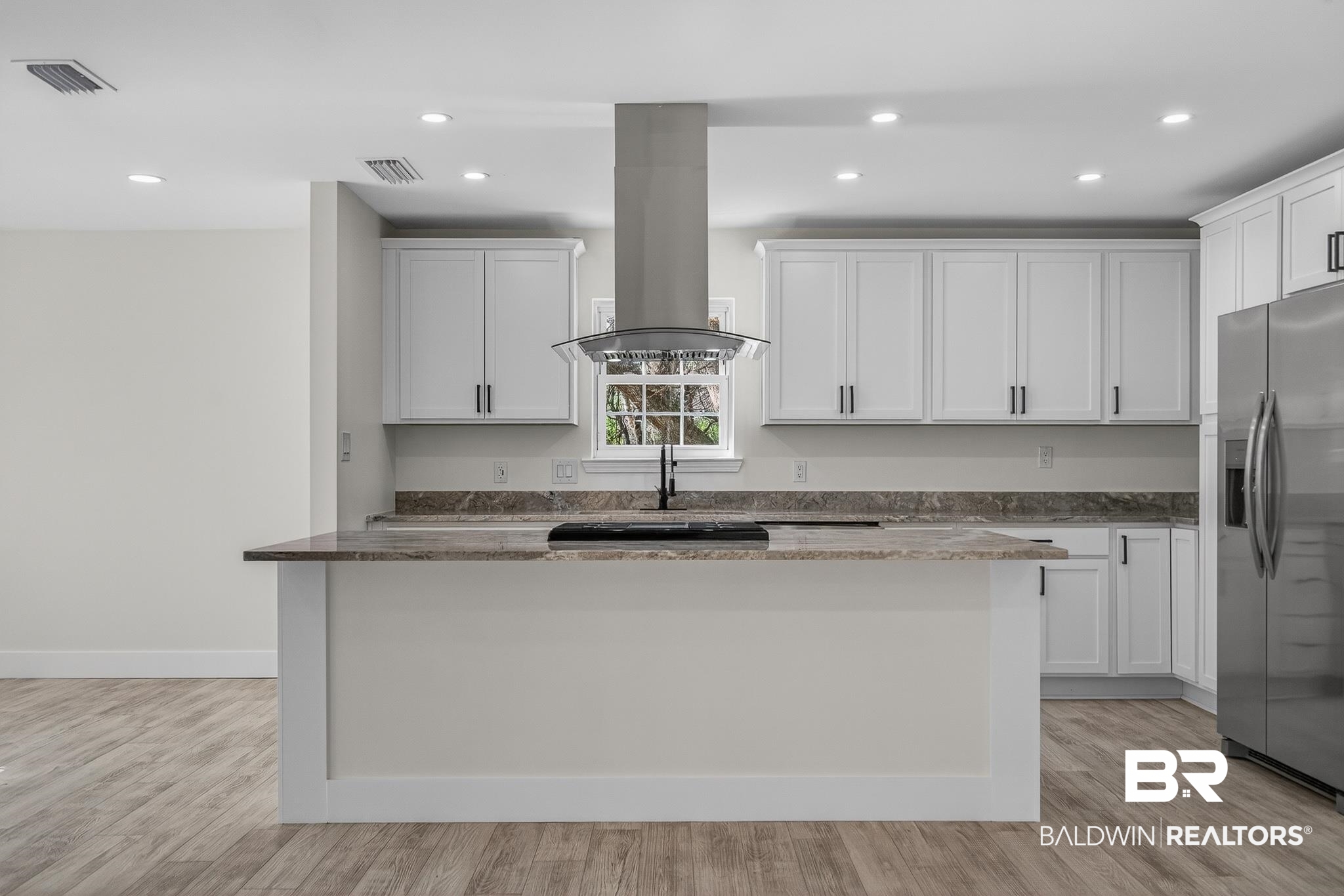 10650 Old Pascagoula Road Theodore, AL 36582 - Photo 18 of 77 Kitchen with a kitchen island, stainless steel fridge with ice dispenser, white cabinetry, dark stone countertops, and recessed lighting