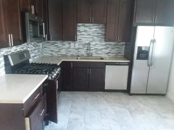 a kitchen with granite countertop a sink and a stove