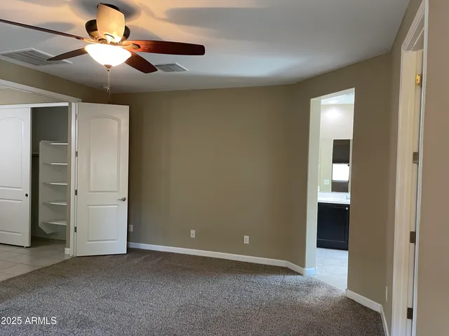 an empty room with closet and fan