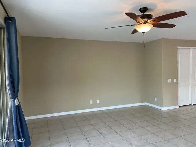 en house with a ceiling fan and carpet