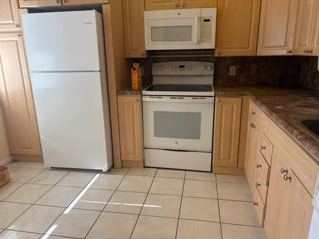 a kitchen with granite countertop a sink a stove and cabinets