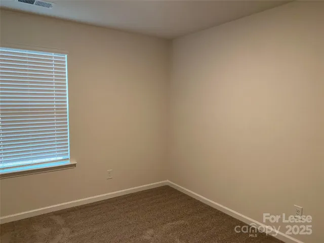 a view of a small space with wooden floor and a window