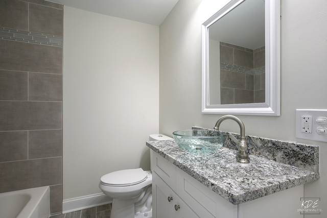 12N234 South Randall Road Elgin, IL 60123 - Photo 23 of 33 a bathroom with a granite countertop sink a toilet and a mirror