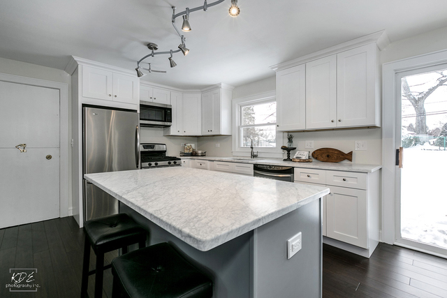 12N234 South Randall Road Elgin, IL 60123 - Photo 9 of 33 a kitchen with stainless steel appliances granite countertop a stove a sink dishwasher a refrigerator white cabinets and wooden floor