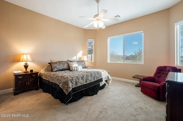 a spacious bedroom with a bed window and couch