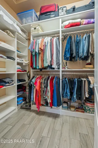 a view of walk in closet with clothes