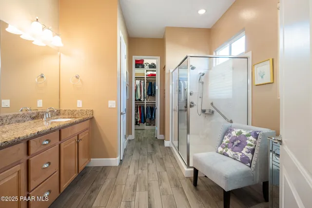 a spacious bathroom with a granite countertop sink mirror and a shower